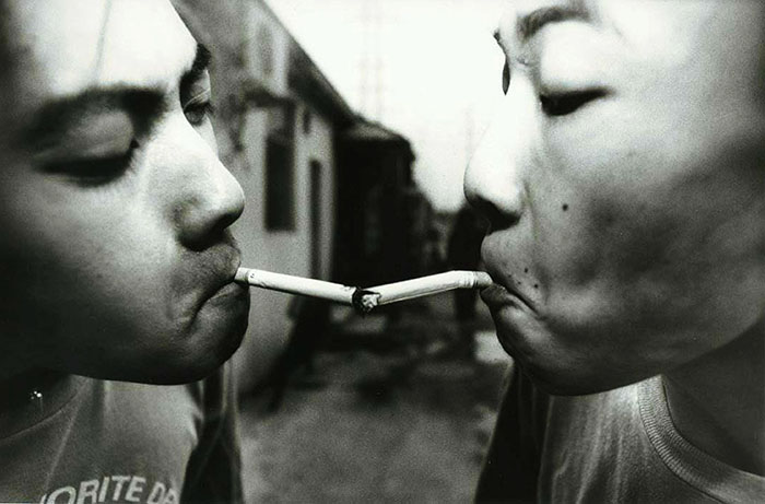 BEIJING, AUGUST 1999: Shen Yue (left) and Tu Qiang(right) sharing a cigarette in the afternoon in the alley where the Scream bar is located.The Beijing punks often spend their afternoons smoking&drinking in that alley before they get ready to perfrom at the Scream bar.